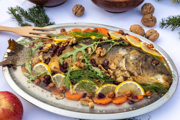 carp with lemon, walnuts and raisins on the plate