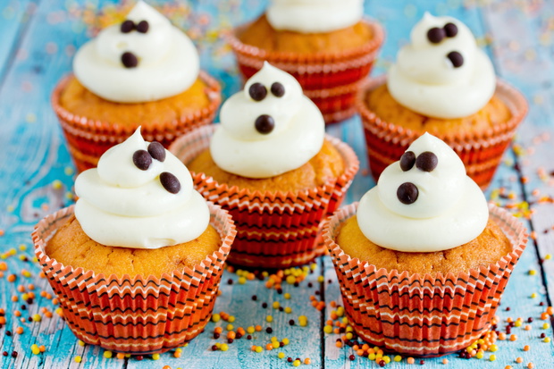 Halloween ghost cupcakes , homemade sweet pumpkin cakes with cre