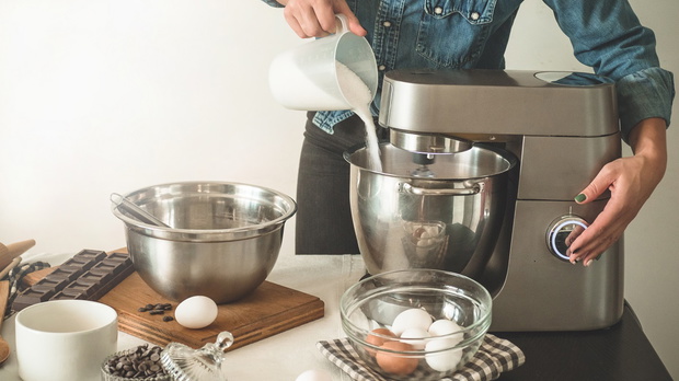 Confectioner girl in a denim shirt is preparing a cake. Concept