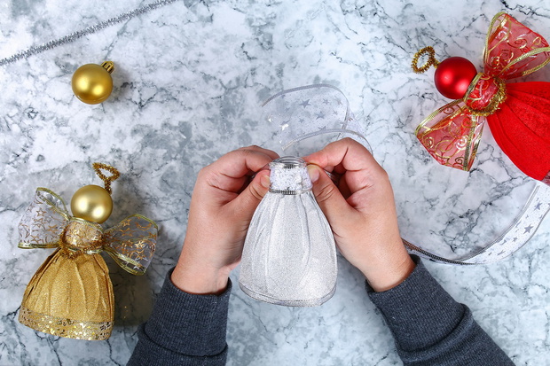 Diy Angel plastic bottle. Guide on the photo how to make a decorative angel from a bottle, self-adhesive shiny paper, ribbon and a Christmas ball with your own hands. Handmade. Top view. Step by step