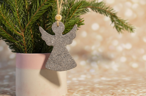 Fresh fir branches in concrete flowerpots decorated with an ange