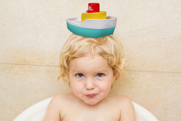 smiling child bathing in the bathroom with foam