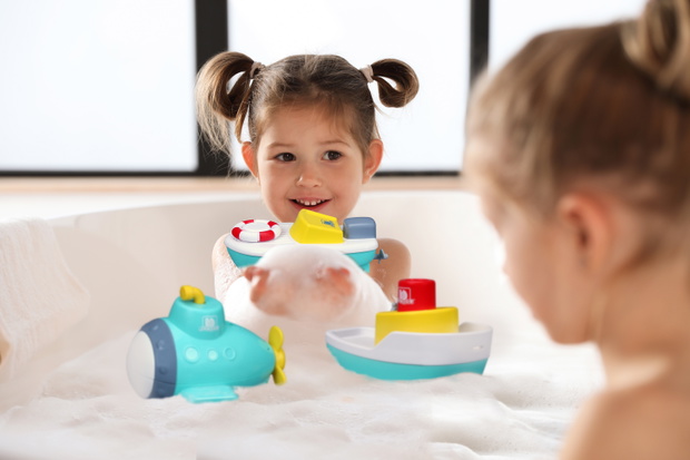 Cute little sisters taking bubble bath together