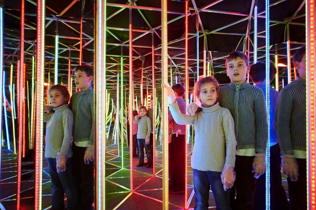 Boy and his younger sister wander in semidarkness of mirror laby