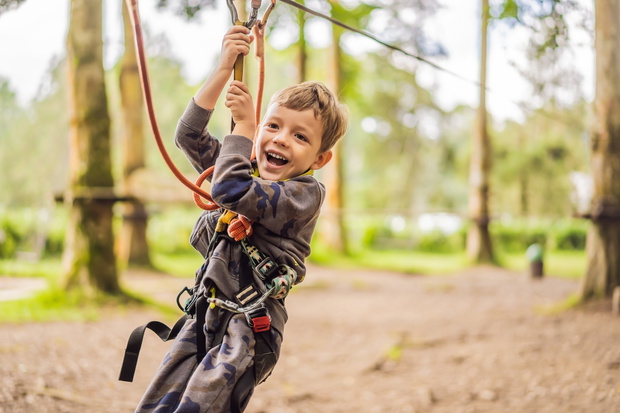 Little boy in a rope park. Active physical recreation of the child in the fresh air in the park. Training for children