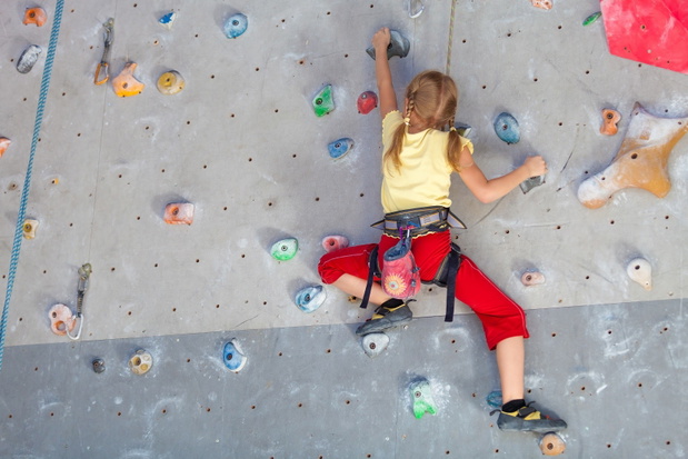 little girl climbing a rock wall