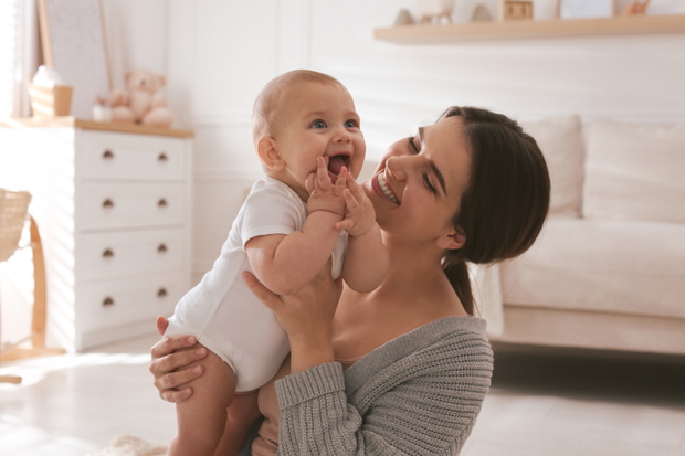 Happy young mother with her cute baby at home