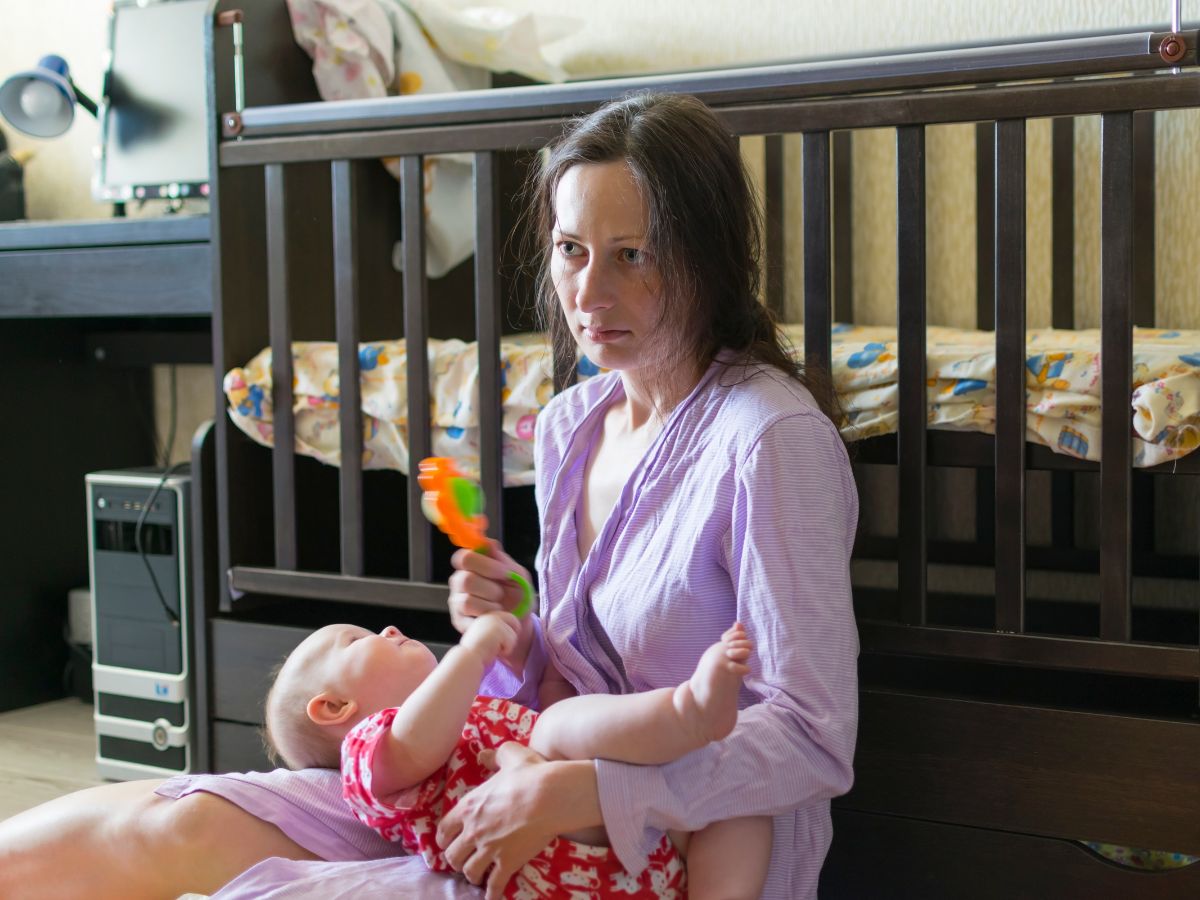 zmęczona macierzyństwem mama z małym dzieckiem