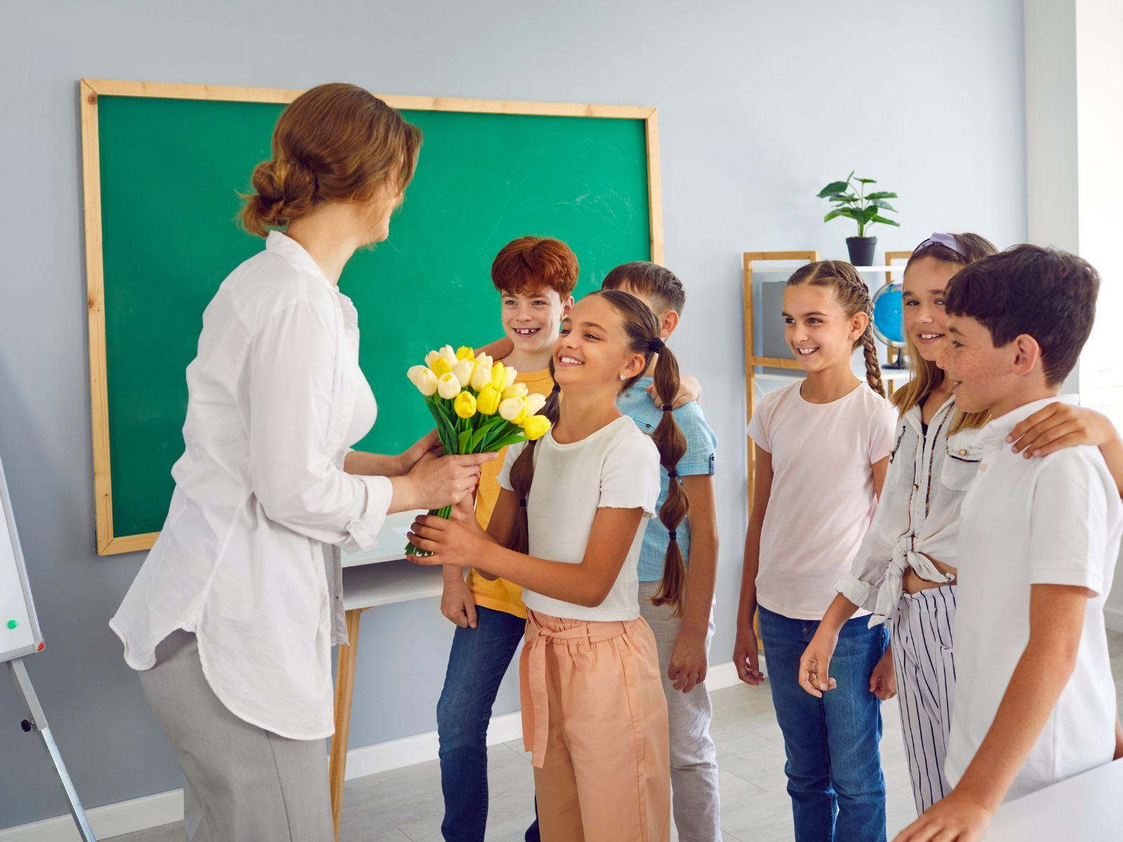nauczycielka przyjmuje kwiaty na Dzień Nauczyciela