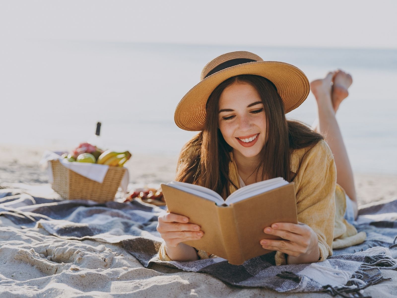 dziewczyna na plaży czyta książkę
