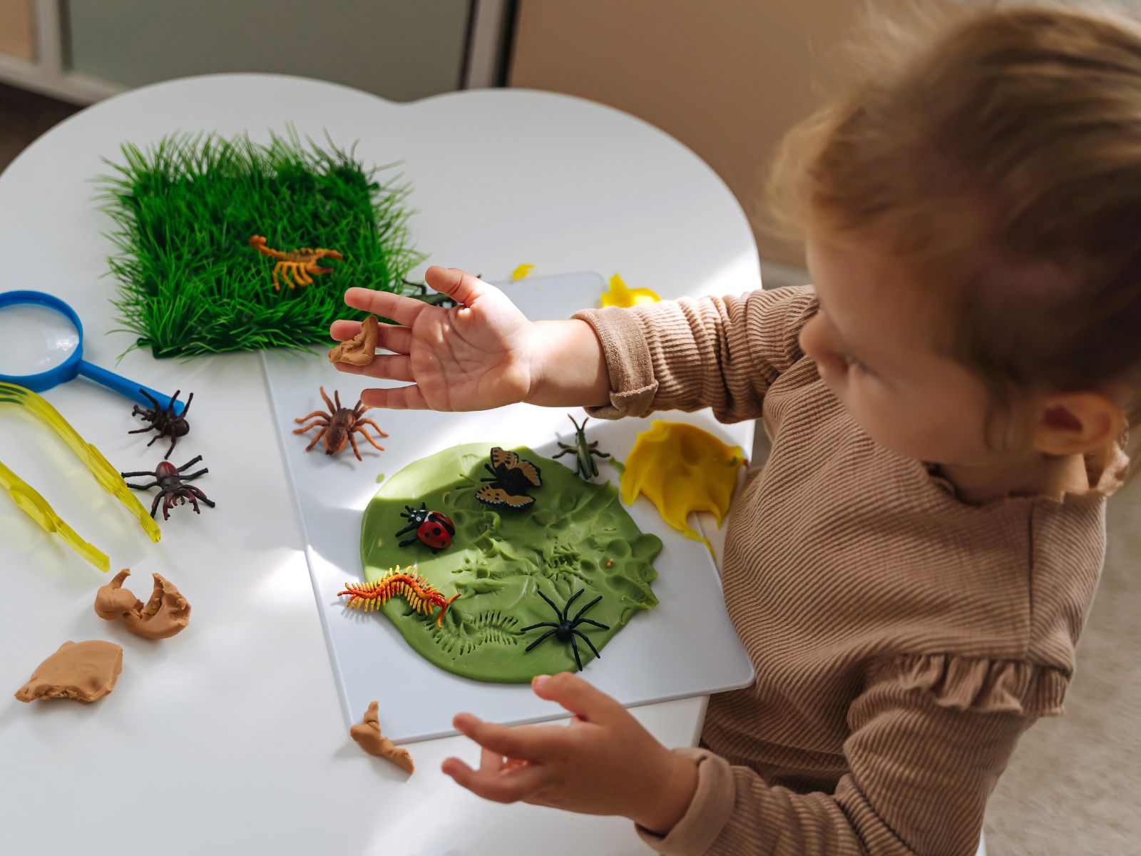 kilkuletnie dziecko bawi się zabawkowymi insektami