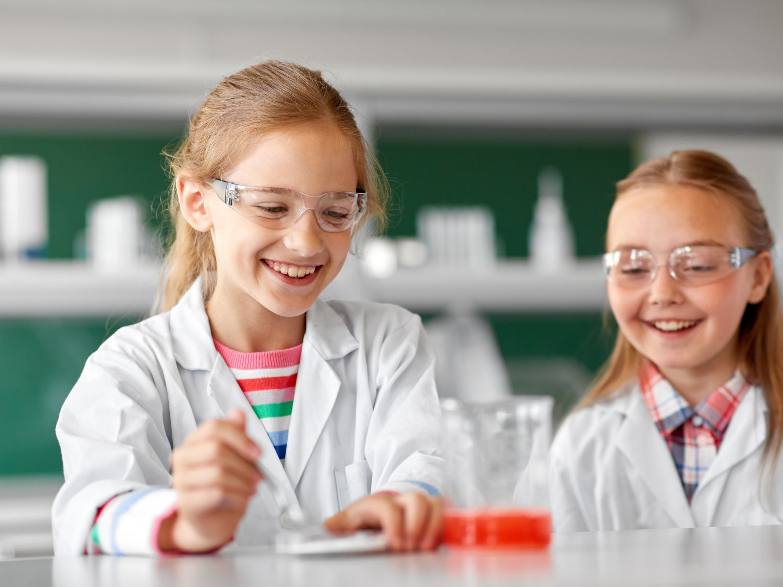 dziewczynki robiące doświadczenia chemiczne