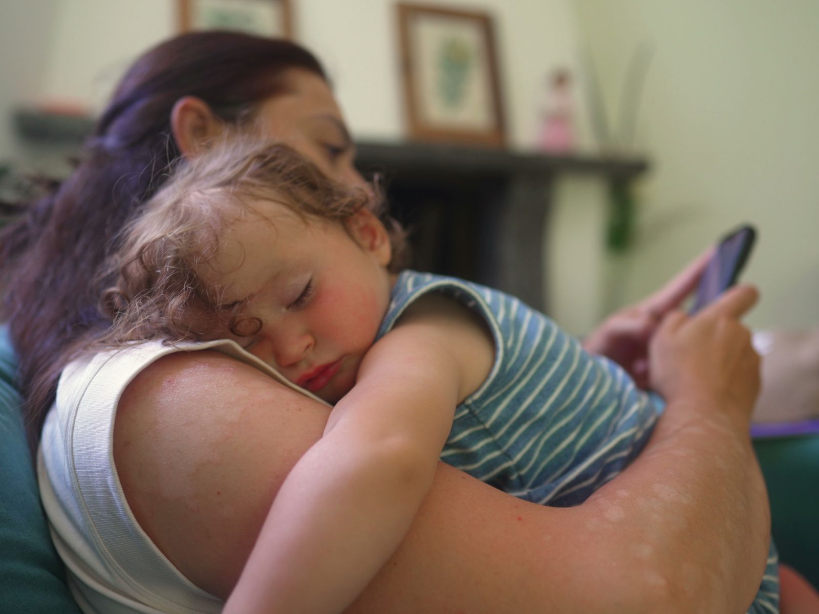 mama ze śpiącym dzieckiem na rękach pisze do kuriera