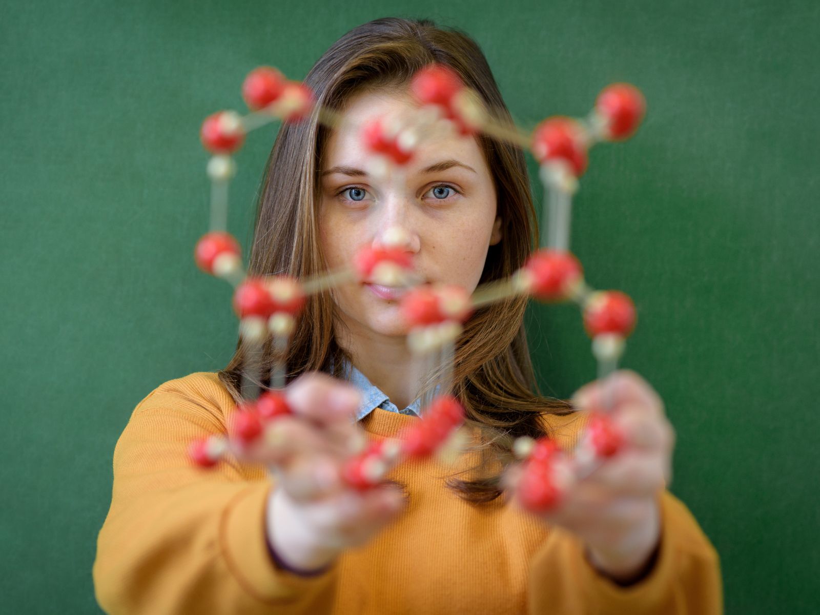 dziewczyna, która trzyma makietę atomów