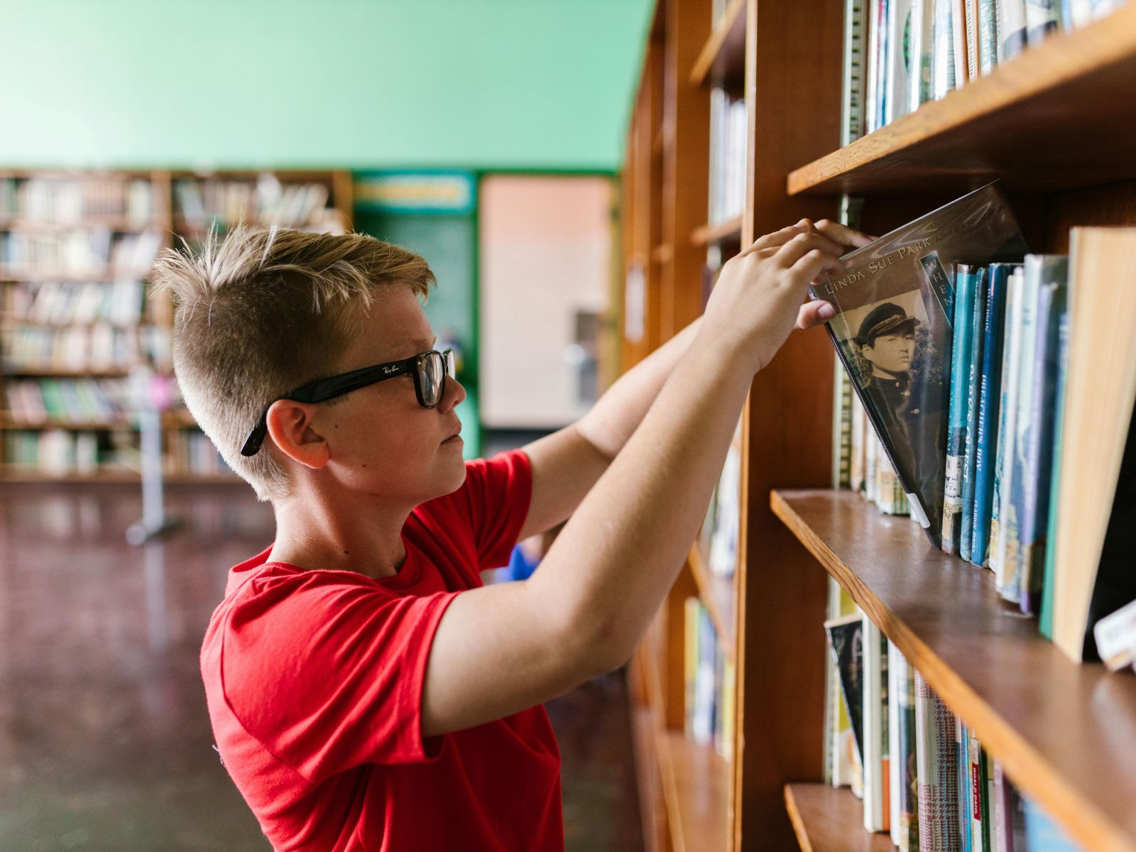 uczeń wybierający lekturę w bibliotece