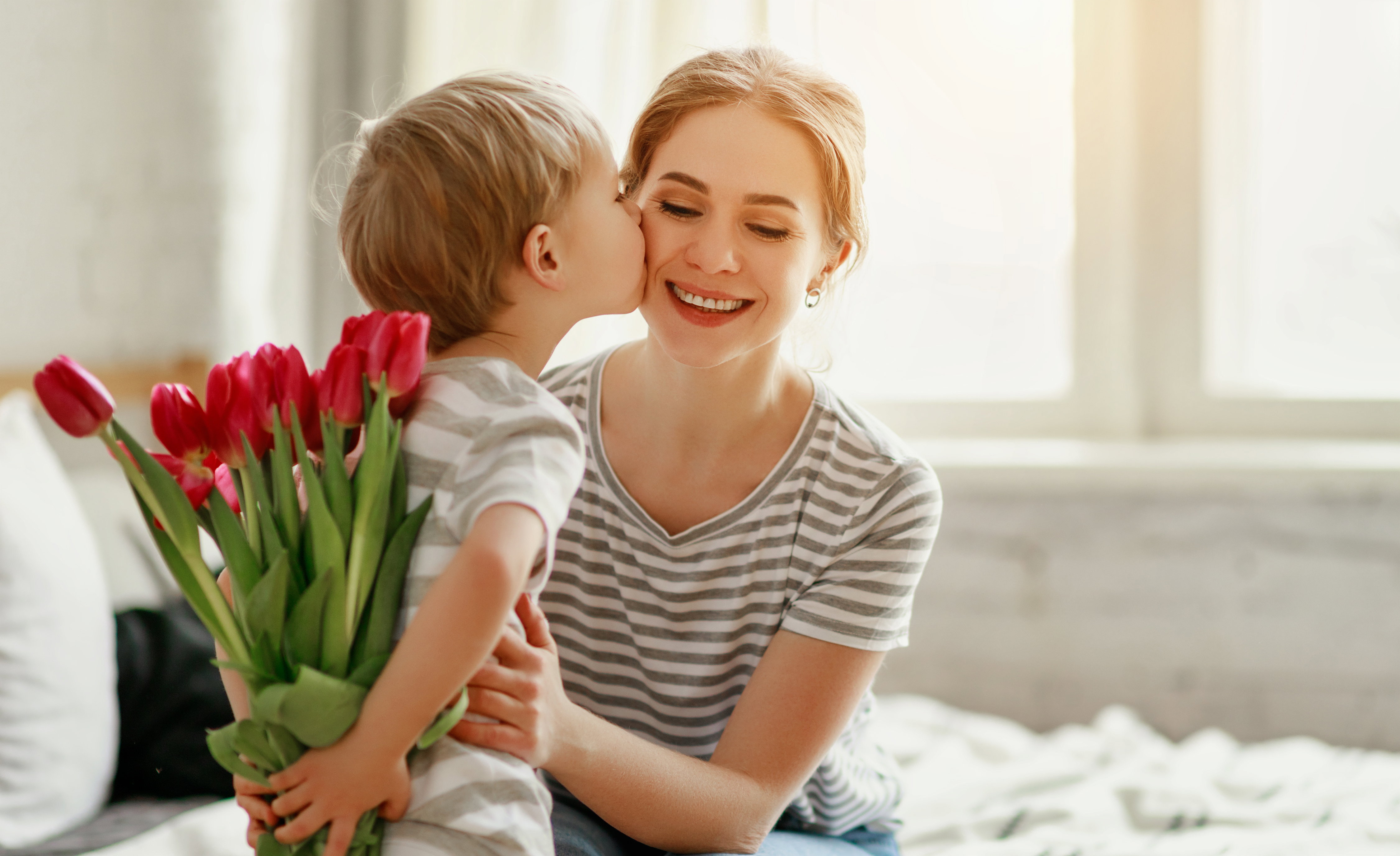 happy mother's day! child son gives flowers for  mother on holiday