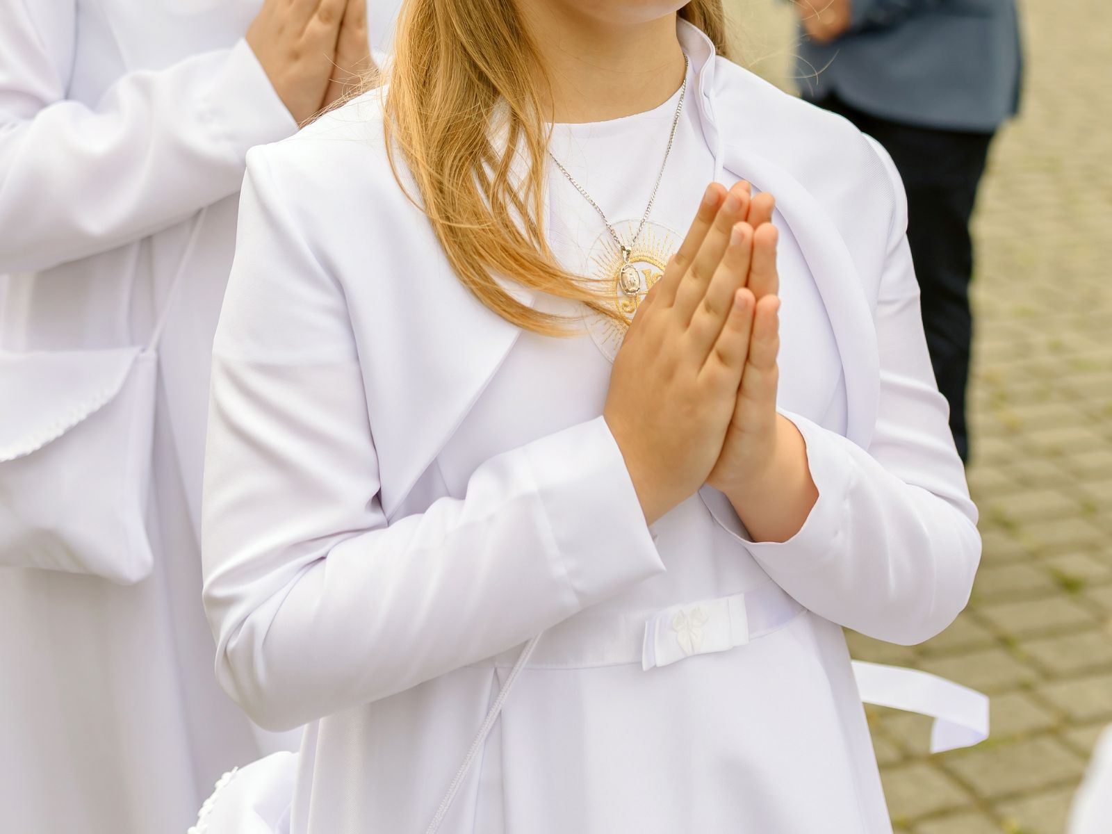 dziewczynka przystępująca do komunii ze złotym naszyjnikiem