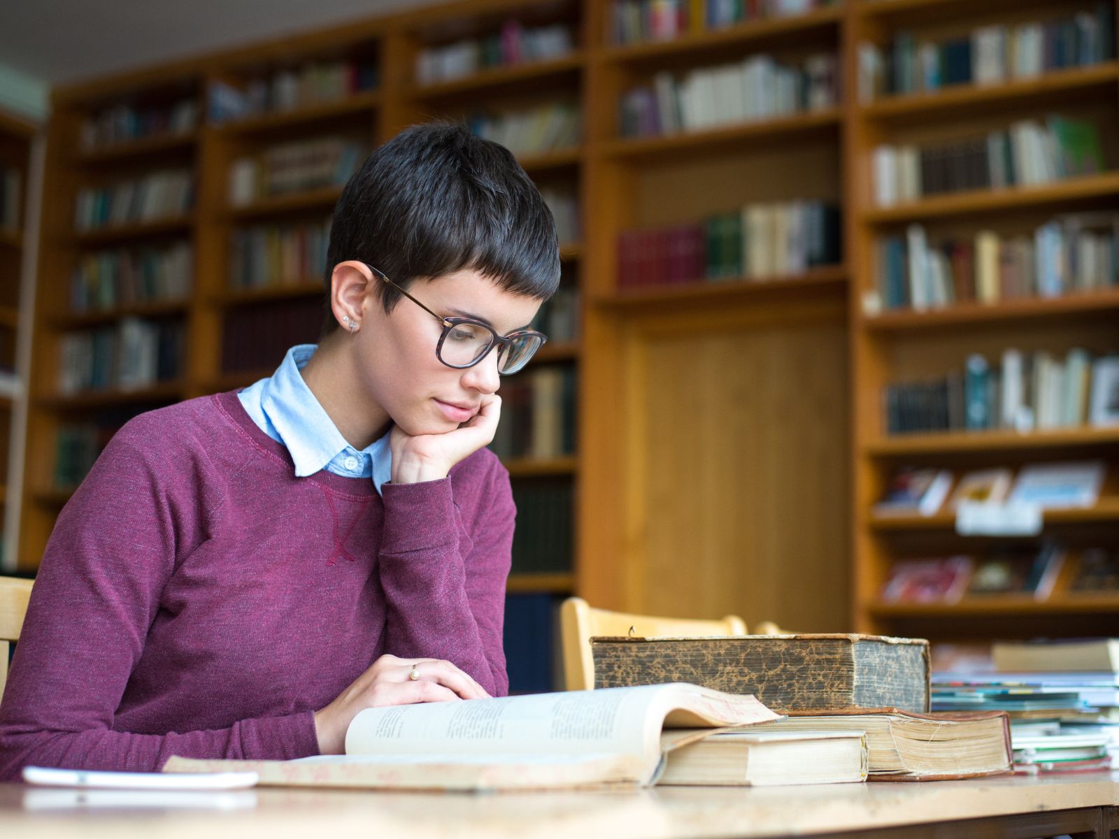 dziewczyna czytająca książkę w bibliotece