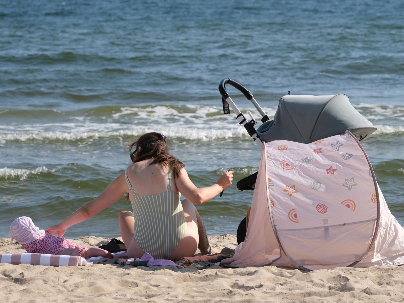 młoda mama na plaży z dzieckiem