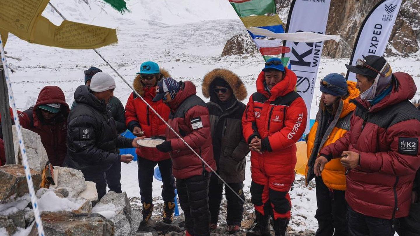 Himalaiści i Szerpowie w trakcie tradycyjnej ceremonii Puja (fot. Facebook/Nims Purja)