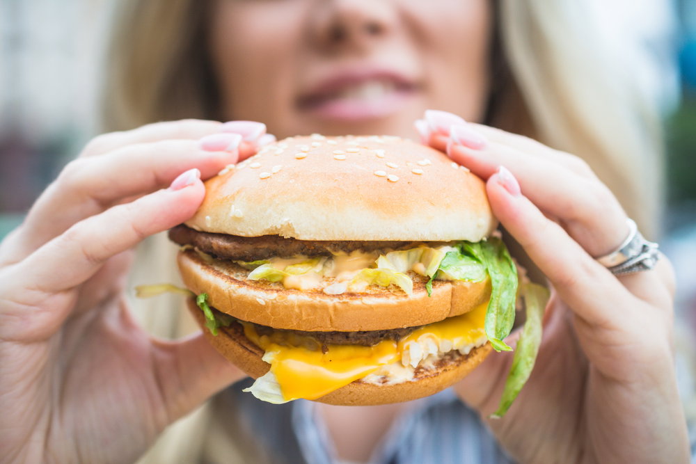 Girl,Holding,A,Cheeseburger,Or,Hamburger,In,Her,Hands,In