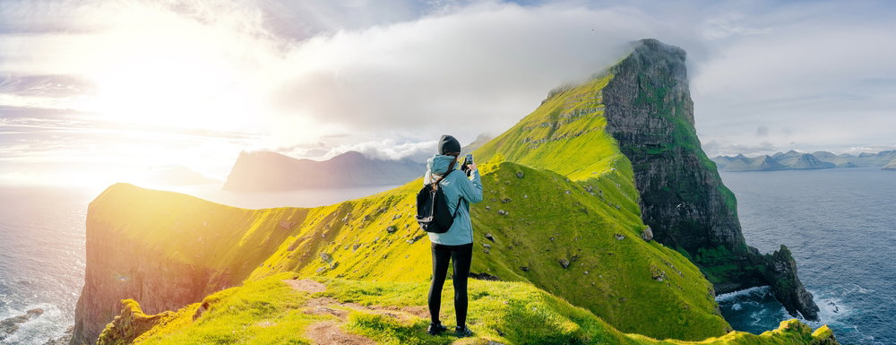 Happy,Woman,Hiker,Using,Smartphone,Taking,Photo,At,Coast,Cliff
