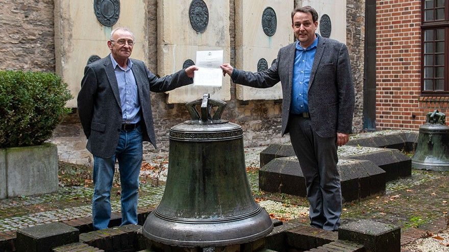 Hans Manek (po lewej) i prof. Thomas Flammer vor der Glocke pozują przy zabytkowym dzwonie (fot. bistum-muenster.de)