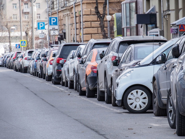 A microcar is parked across the roadway in a paid parking