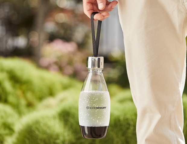Mężczyzna niosący butelkę z wodą gazowaną SodaStream 0,5 l - zdjęcie.