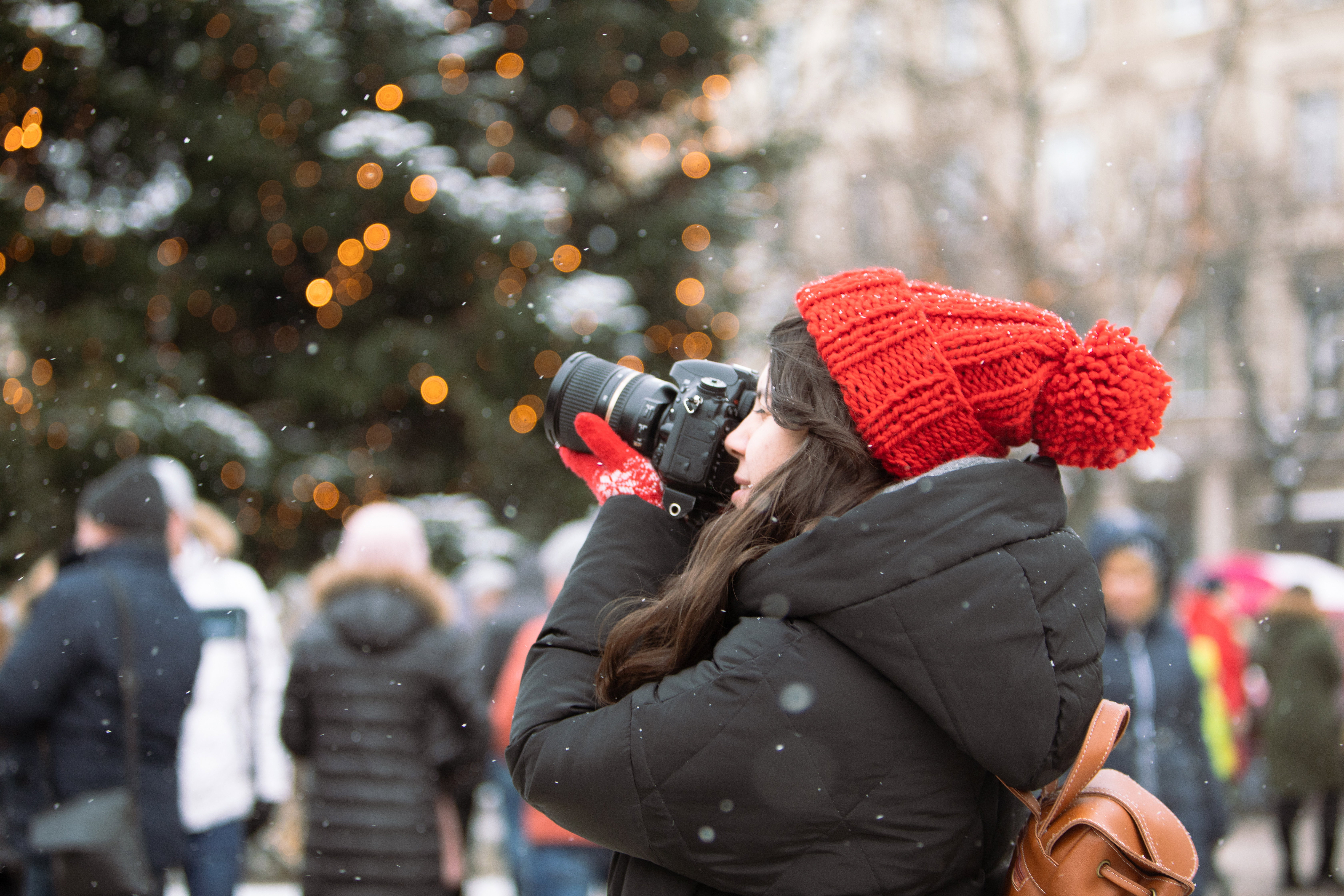 woman photographer with professional camera shooting outdoors at winter time