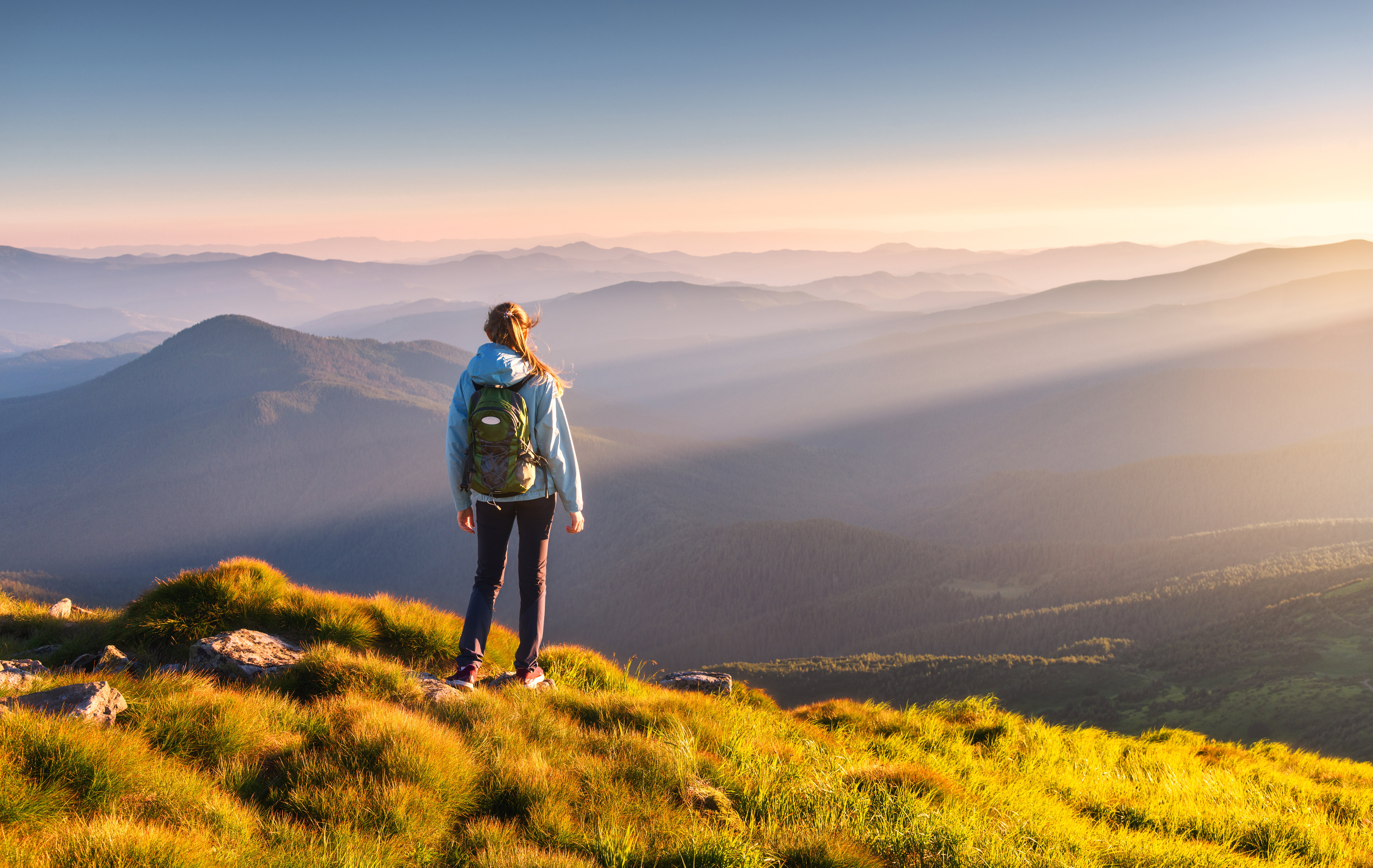 Beautiful mountains in fog and standing young woman with backpac