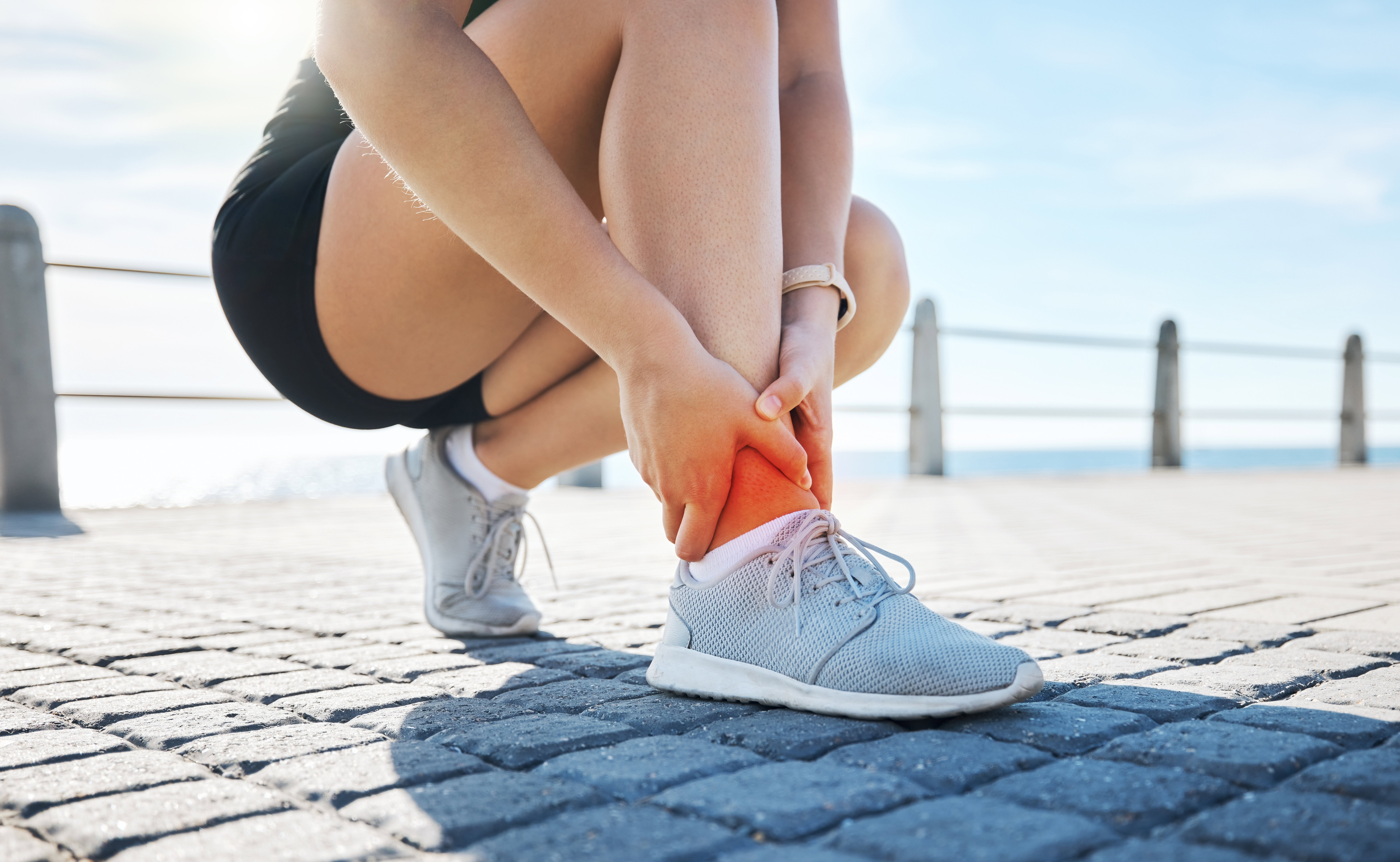 Fitness,,Hands,Or,Runner,With,Ankle,Pain,At,A,Beach