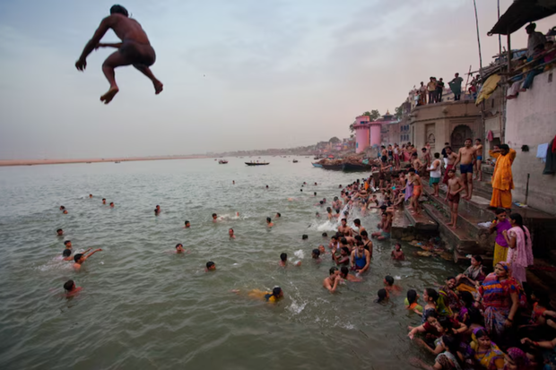 Ludzie skaczący do świętej rzeki Ganges w indyjskim Waranasi, 2009 r. / fot. John Stanmeyer, Nat Geo Image Collection