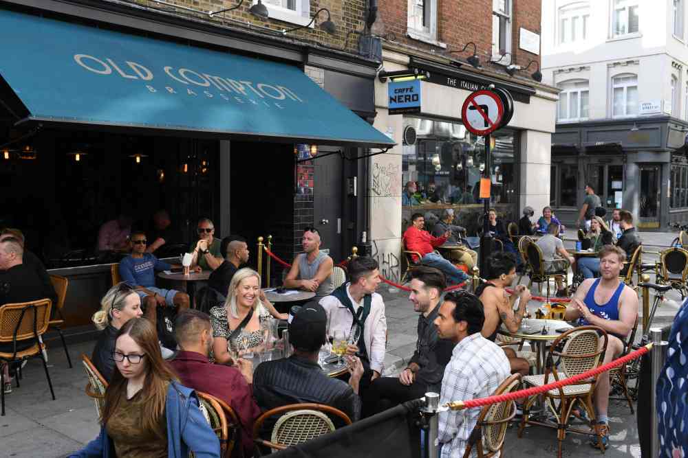 Klienci siedzą przed ponownie otwartymi barami w Soho w Londynie w dniu 5 lipca 2020 r. fot. DANIEL LEAL-OLIVAS/AFP/East News