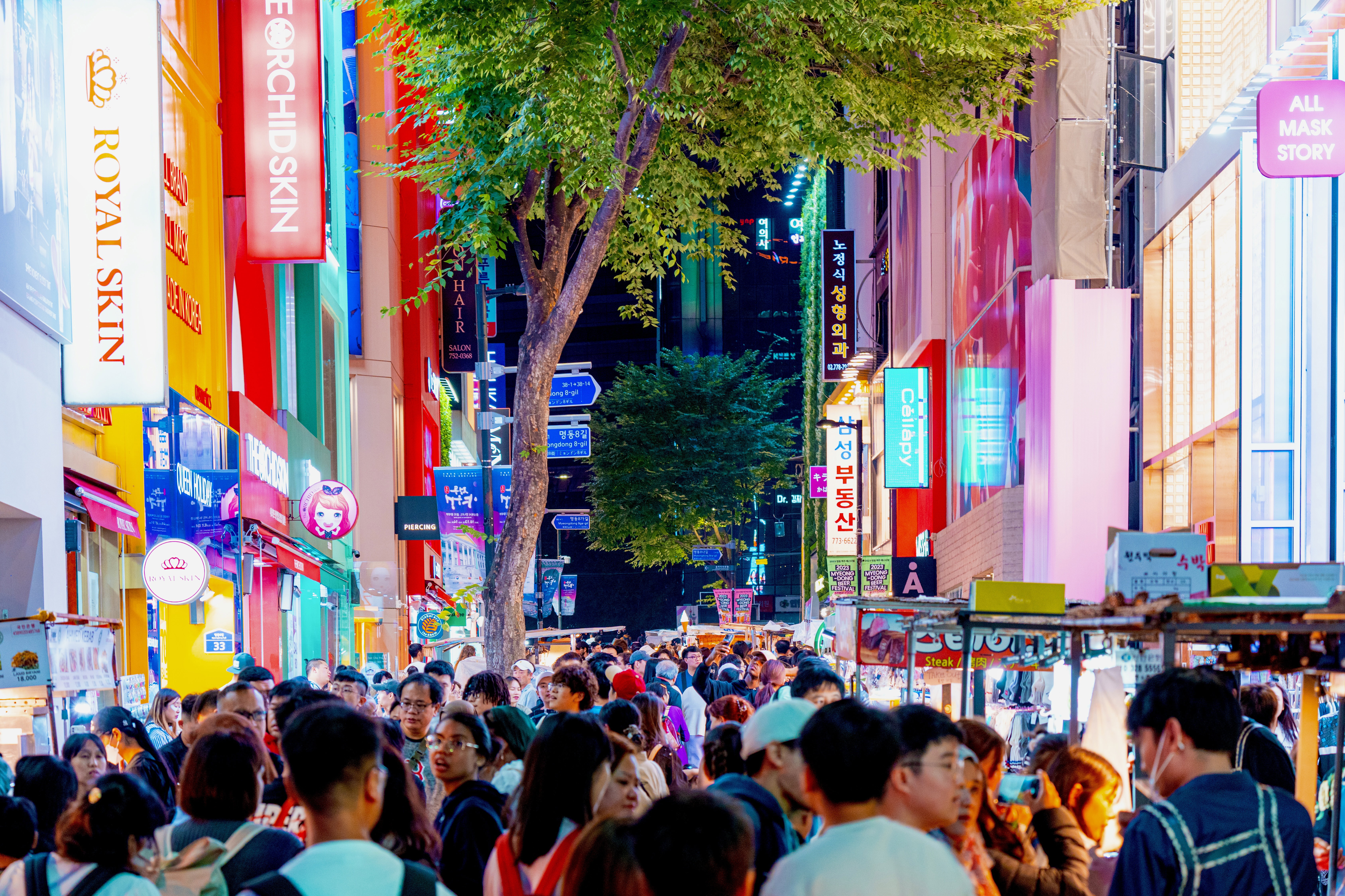 At night, an illuminated telephoto view of street signs in Seoul's Myeongdong shopping district.