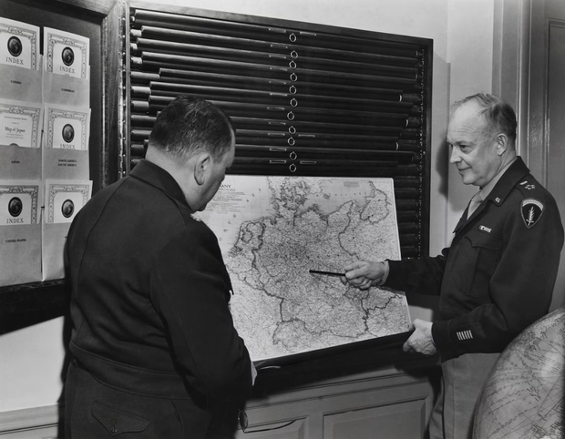 Dwight Eisenhower wskazuje na mapę Niemiec w specjalnym stojaku. National Geographic tworzył takie szafy mapowe dla światowych przywódców. / Fot. B. Anthony Stewart, National Geographic Image Collection