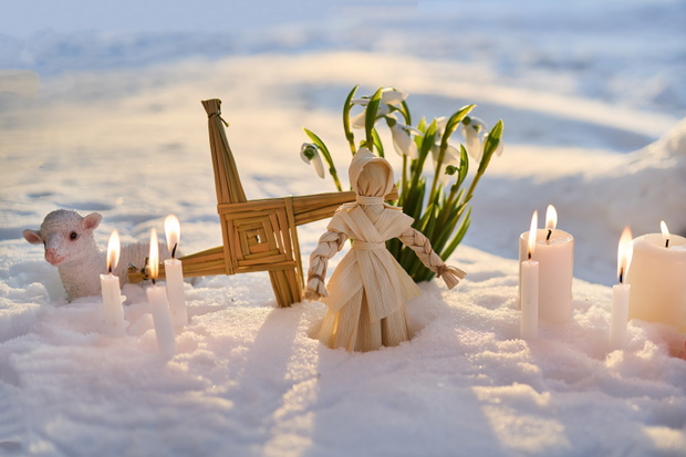 Imbolc altar with brigid's cross, corn dolly, and snowdrops