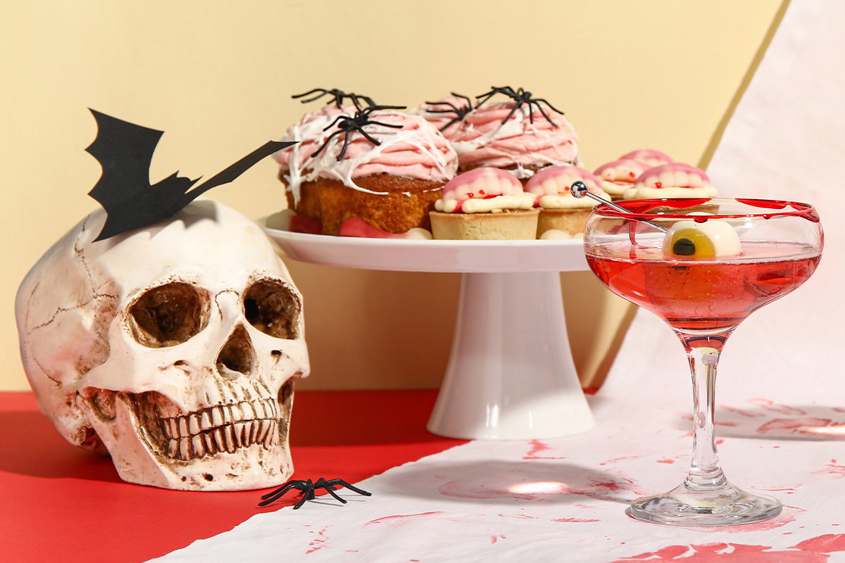 Halloweenowa dekoracja stołu, przekąski i drink.