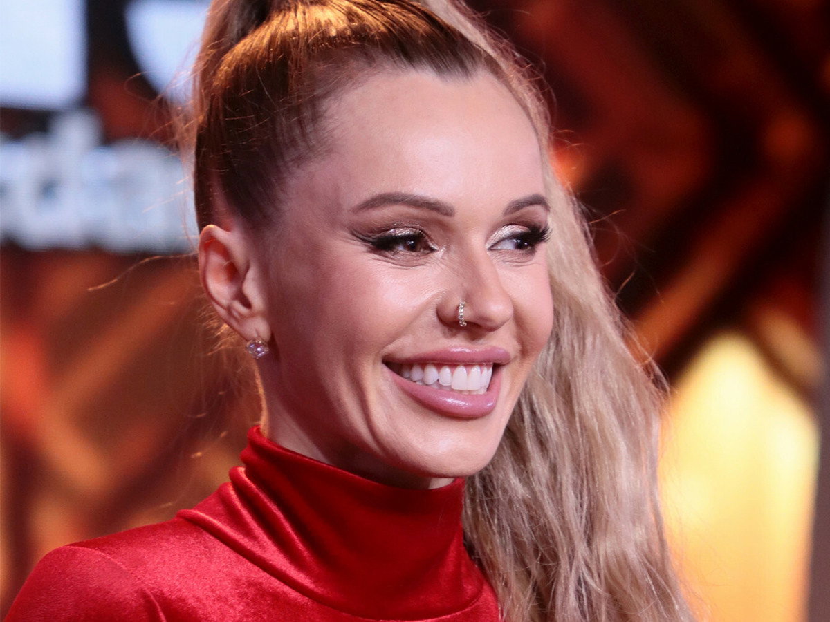 Doda śmieje się ze swojego zdjecia na ściance z premiery Dziewczyny z Dubaju