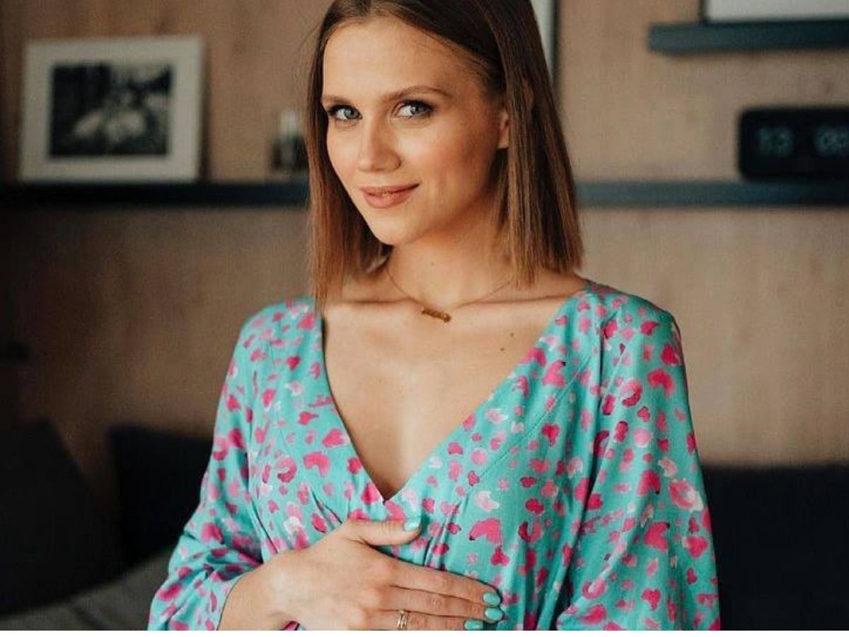 Agnieszka Kaczorowska w niebieskiej sukience w czerwony wzór.