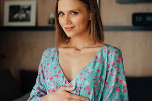 Agnieszka Kaczorowska w niebieskiej sukience w czerwony wzór.