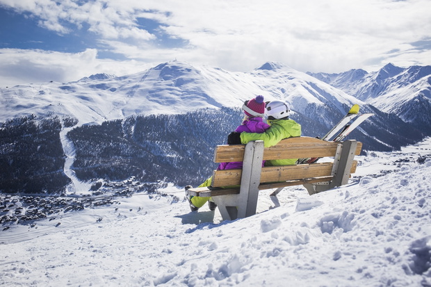 Young couple hugging ski resort winter mountains