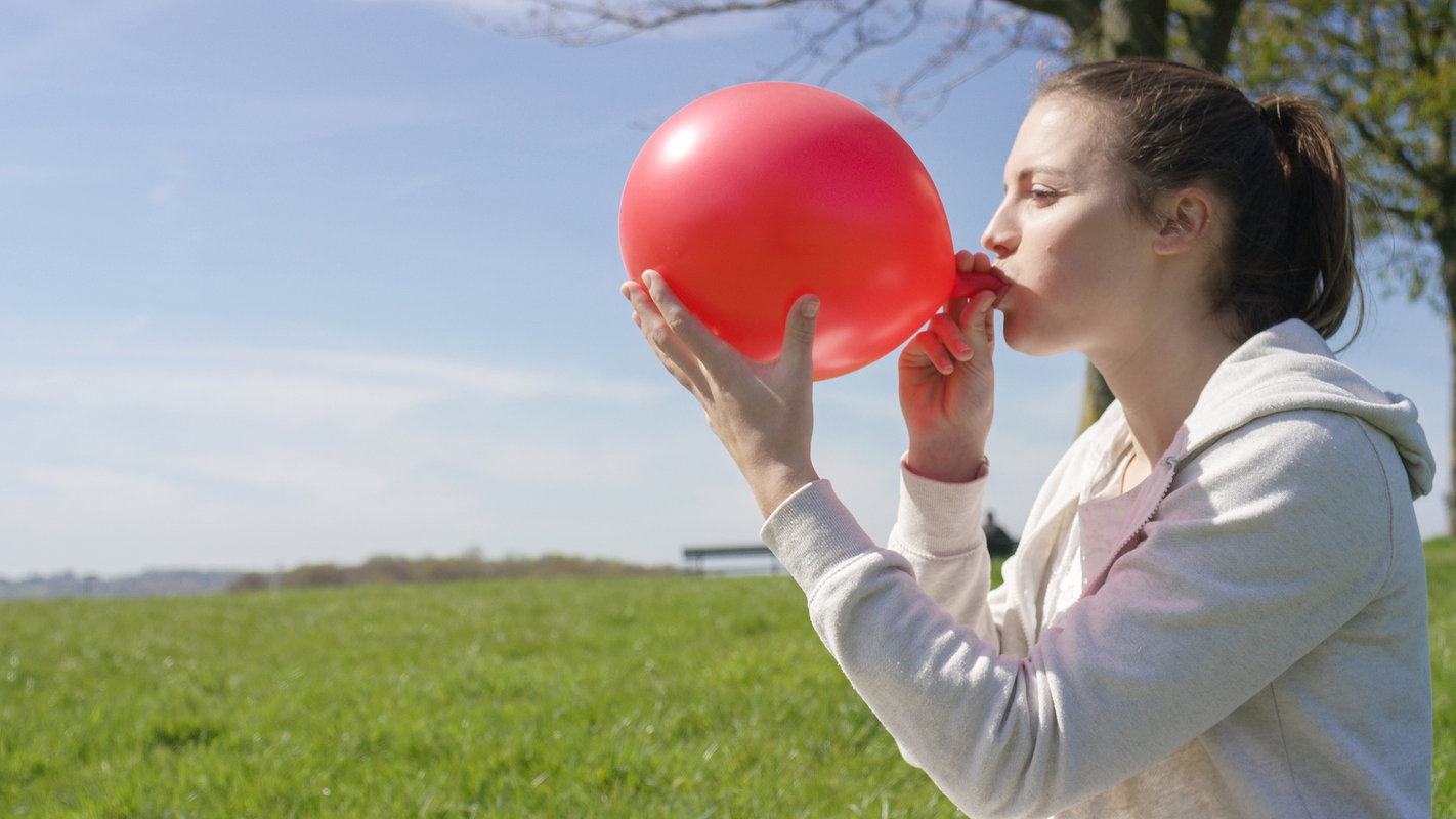 Kobieta nadmuchuje balon