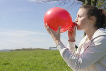Kobieta nadmuchuje balon