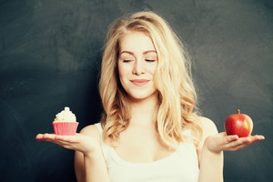 Kobieta wybiera między muffinką a jabłkiem