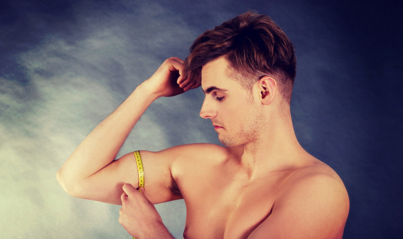 mężczyzna mierzy biceps