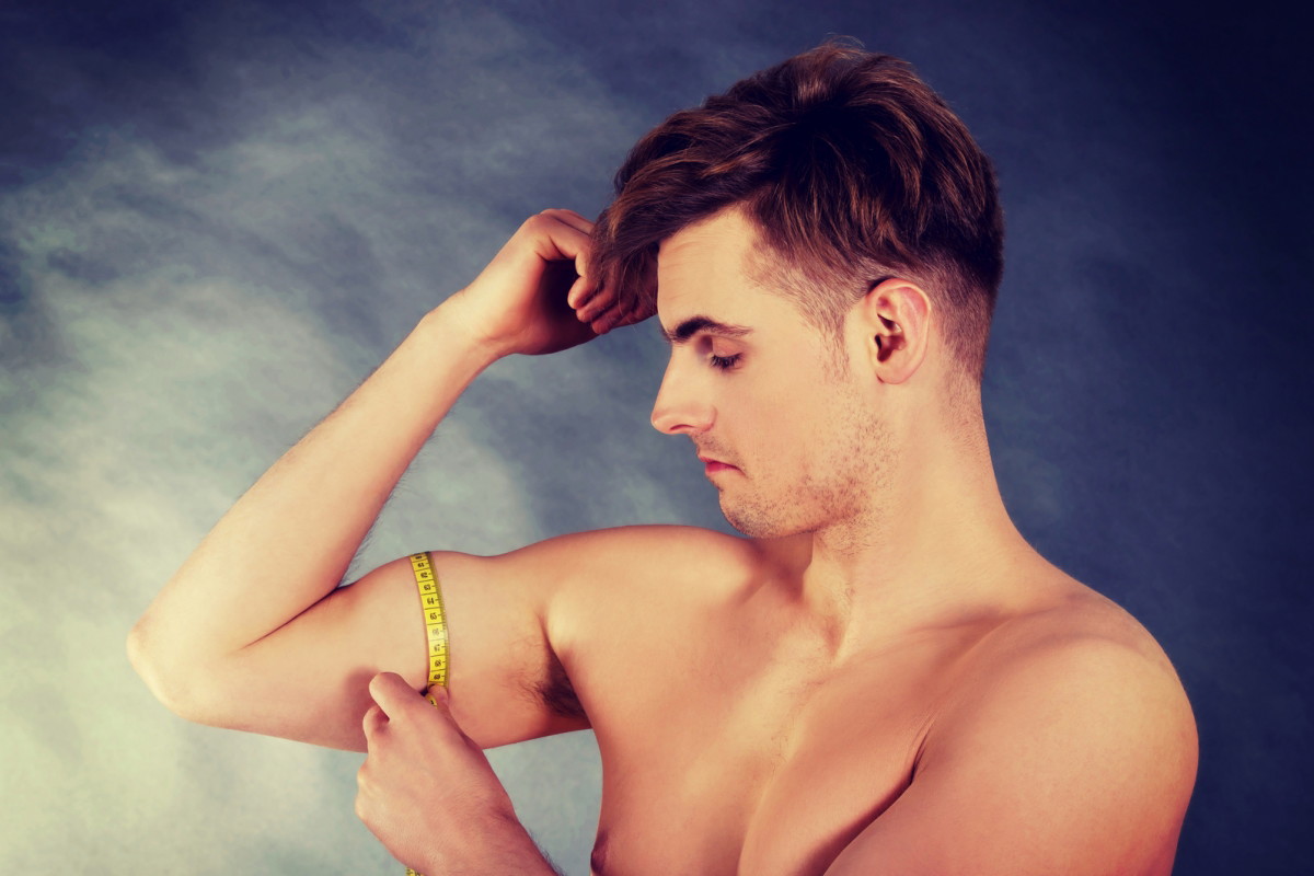 mężczyzna mierzy biceps