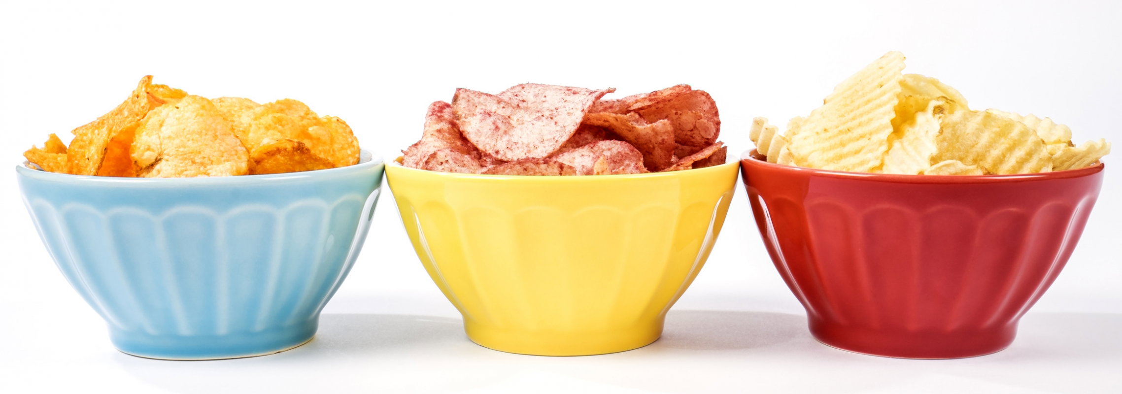 trzy miseczki z czipsami w różnych smakach