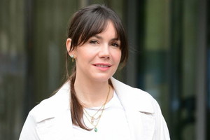 Olga Bołądź w białej bluzce i jasnym płaszczu
