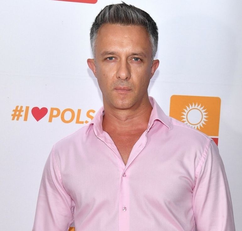 Łukasz Płoszajski w różowej koszuli